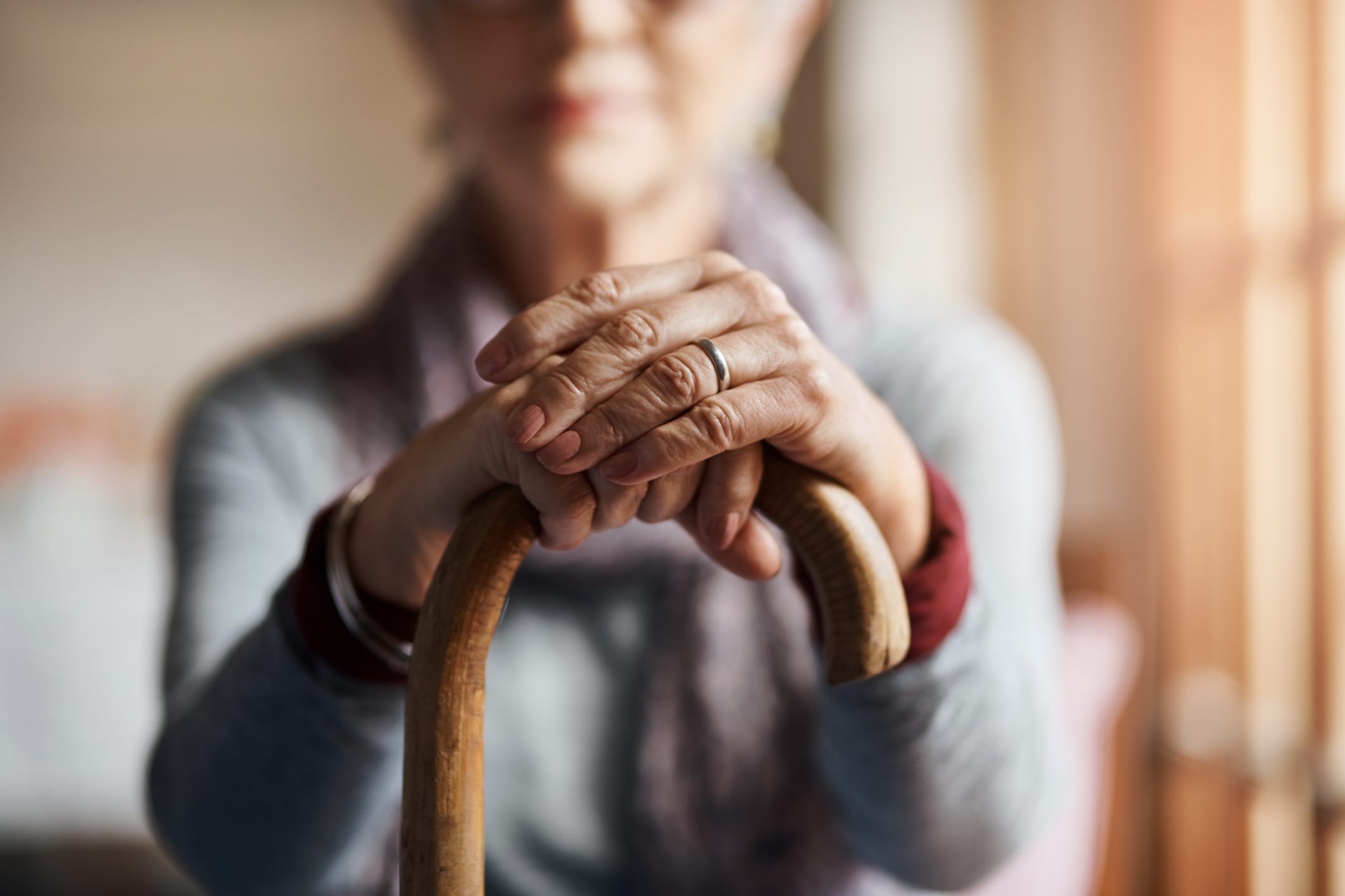 Cropped shot of a senior woman holding a cane in a retirement home