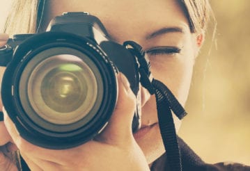 Woman pointing a camera at the viewer