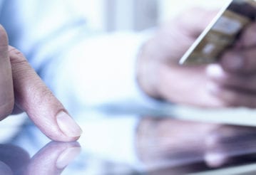 Man making an online purchase on his computer tablet