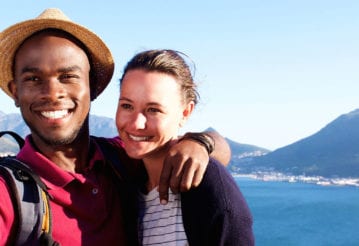 A couple takes a selfie in front of mountains