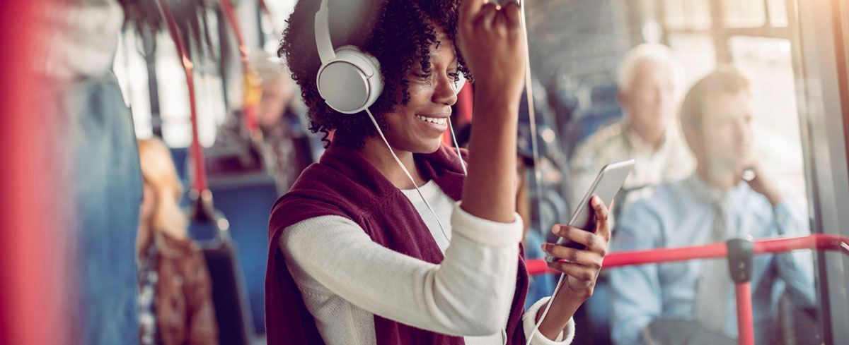 Close up of a young woman listening to music while riding in a bus