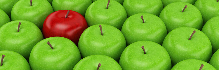 A red apple in the middle of a large number of green apples