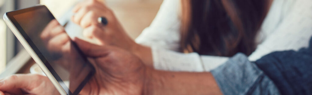 Close up of a hand holding a computer tablet
