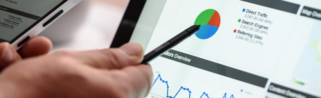 A hand uses a stylus to point to a pie graph on a computer screen
