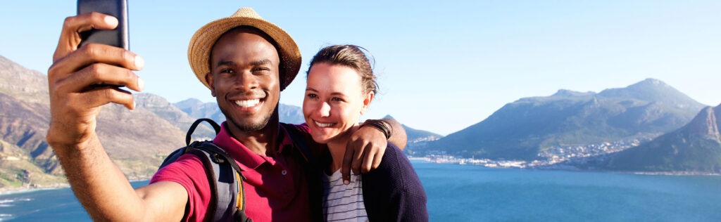 A couple takes a selfie in front of mountains