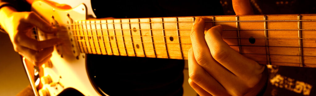Close up of hands playing an electric guitar