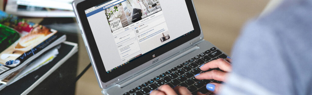 Woman using a laptop to browse facebook