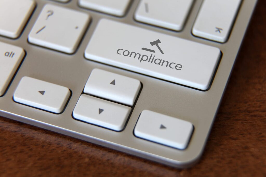 Close up of a keyboard, but instead of a shift key, there is a compliance key